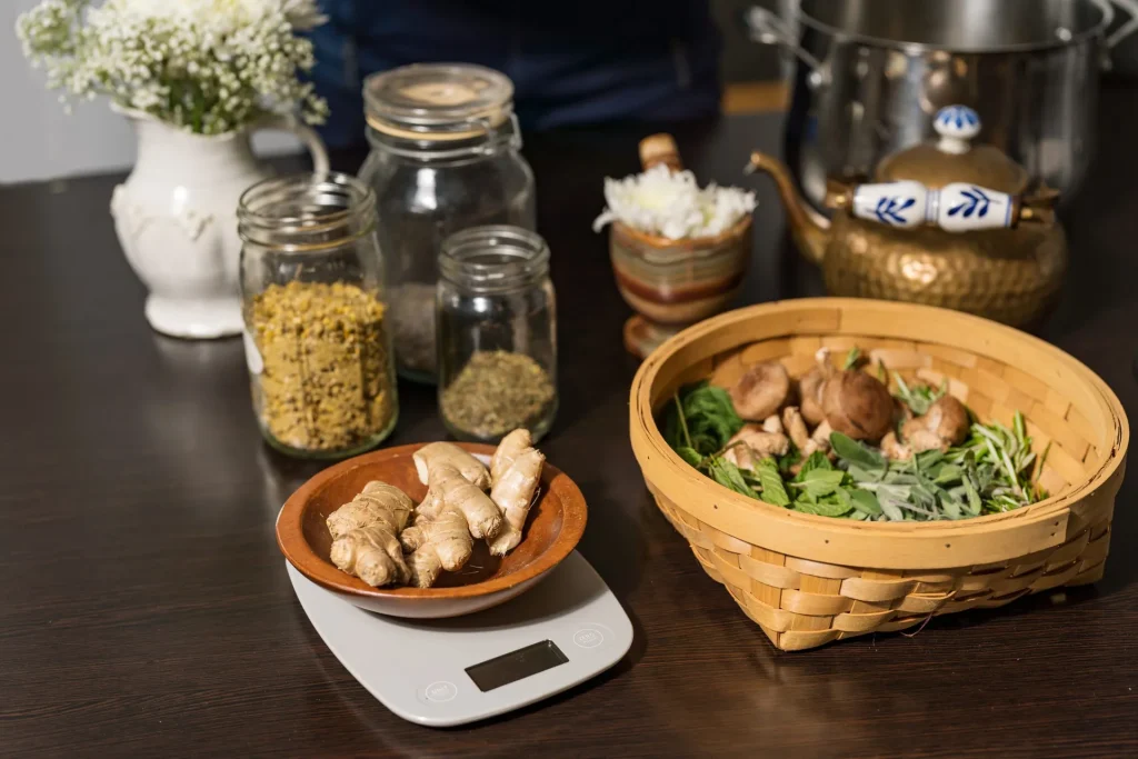 Holistic medicines arranged on table with ginger being weighed on an electric scale